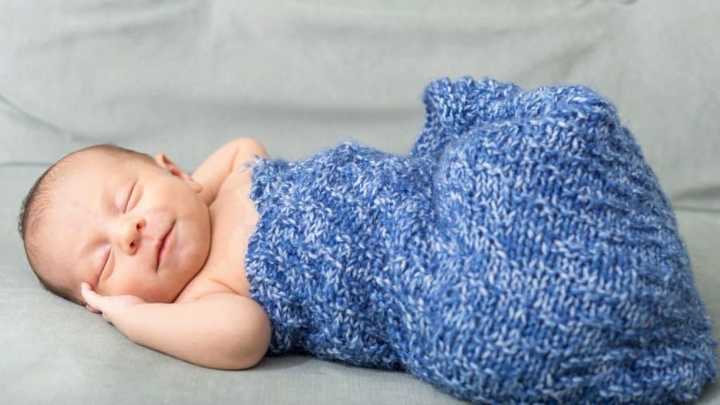 newborn rolling to side in swaddle