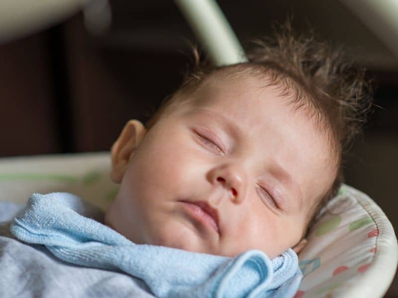 baby is sleeping on baby swing